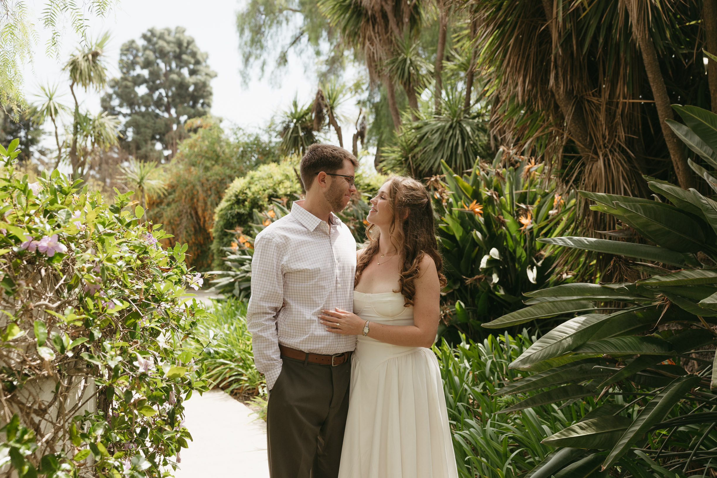 an engaged couple, standing in Rancho Los Alamitos gardens.